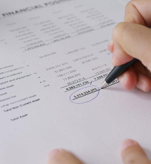 Close-up people hand of female stock trader use pen write on tax plan paper